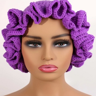 Purple crochet bonnet on a mannequin head with a plain background