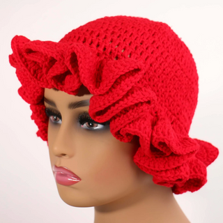 Red knitted headscarf with a bow on a mannequin head against a white background
