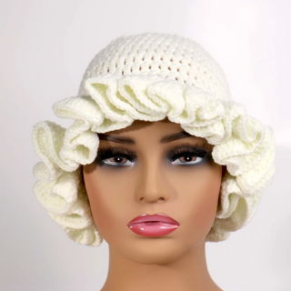 Mannequin head wearing a white crochet hat with floral details on a light gray background
