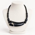 Short black horn necklace on an ivory display bust