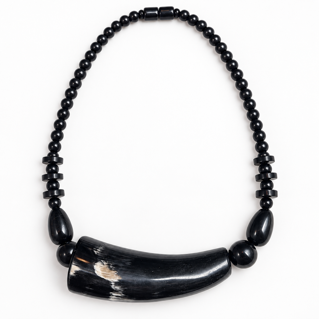 Short black horn necklace laid flat on a light background