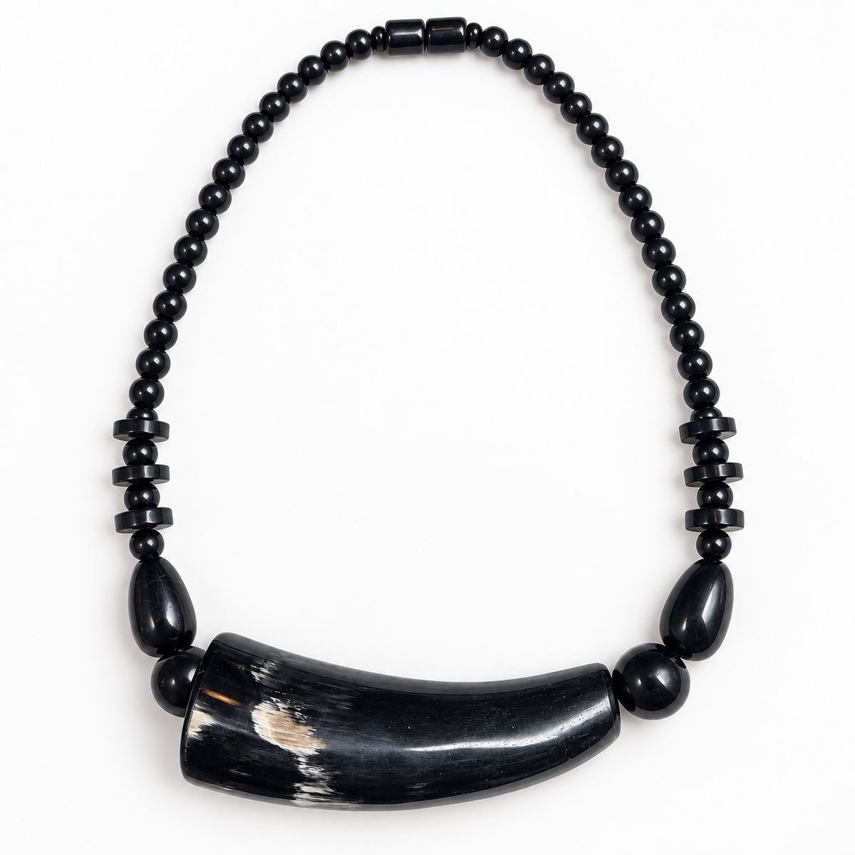 Short black horn necklace laid flat on a light background