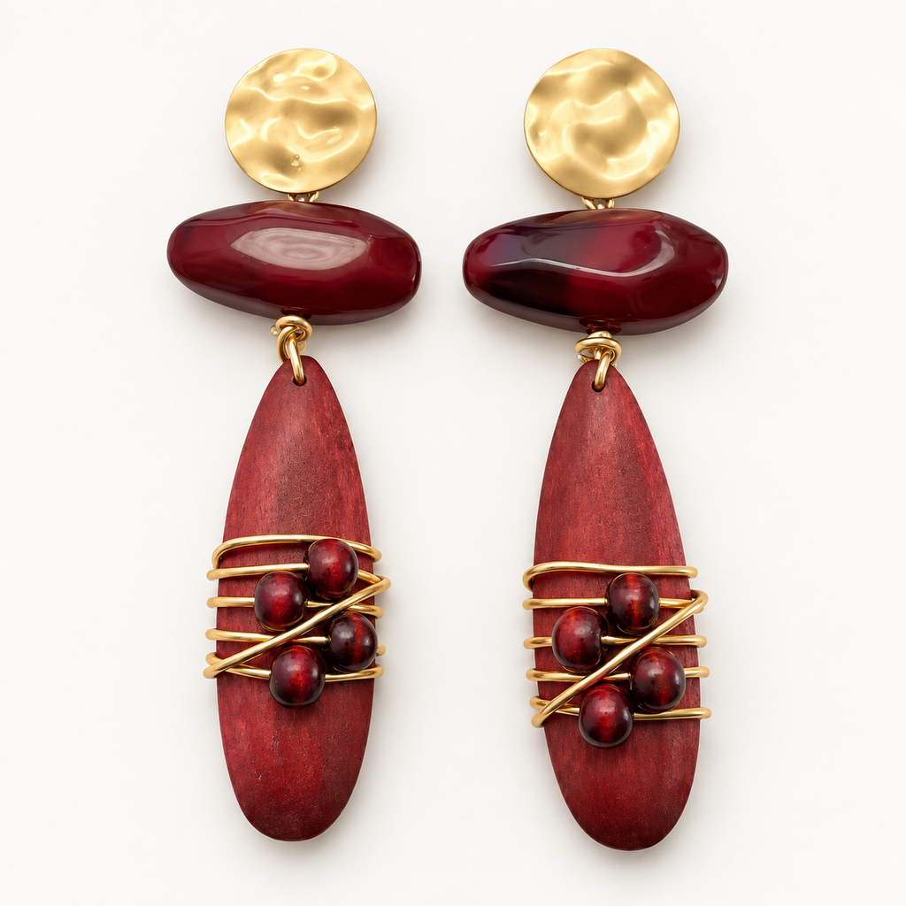 Burgundy wood and gold-tone metal drop earrings lying flat on a light background