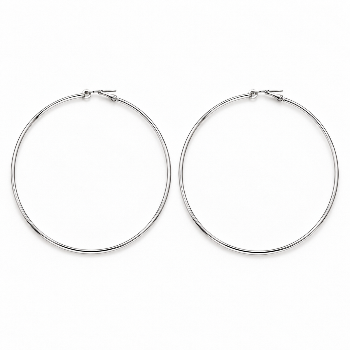 Large slim silver-tone hoop earrings lying flat side by side