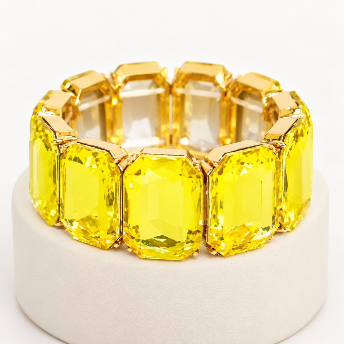 Yellow rectangular crystal stretch bracelet on an ivory display