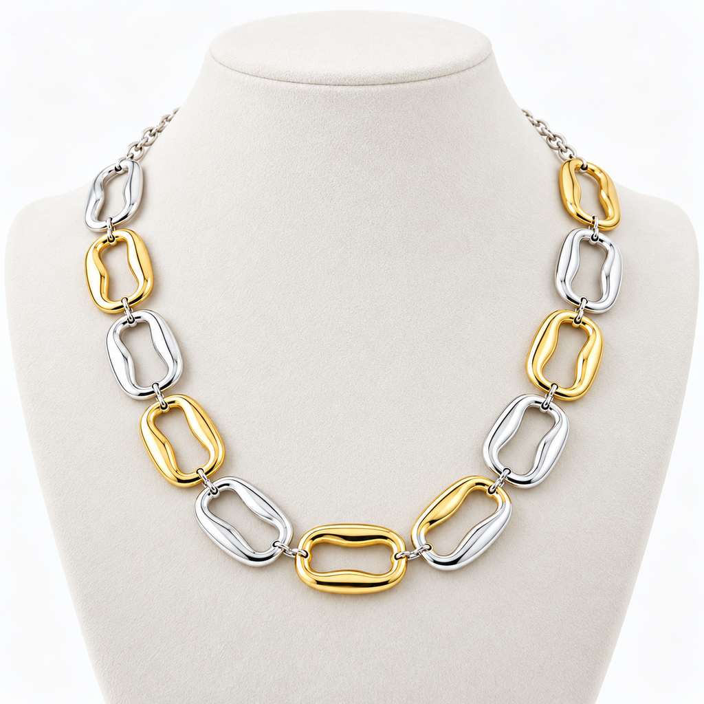 Gold-tone and silver-tone sculpted link necklace on a pale display bust