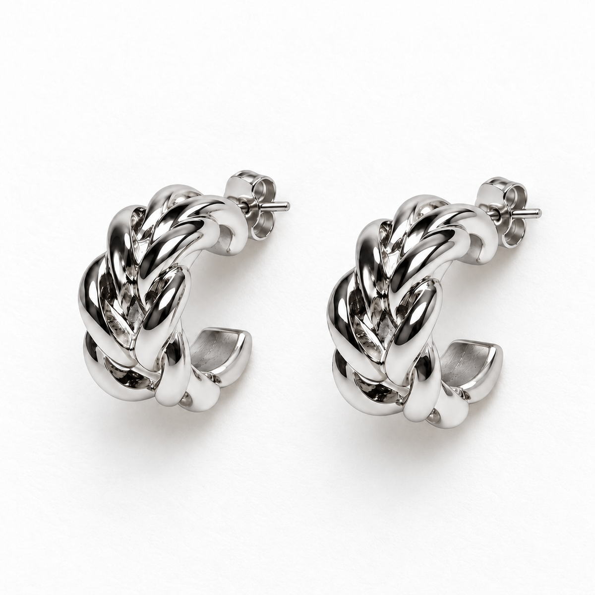 Small silver-tone braided open hoop earrings lying flat