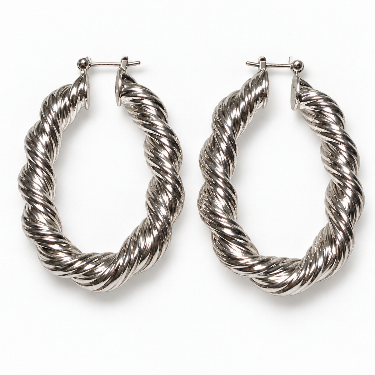 Silver-tone twisted oval hoop earrings laid flat on a near-white background