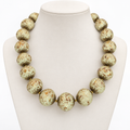 Ivory speckled beaded necklace displayed on a pale bust