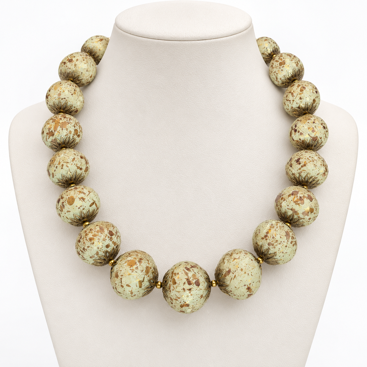 Ivory speckled beaded necklace displayed on a pale bust