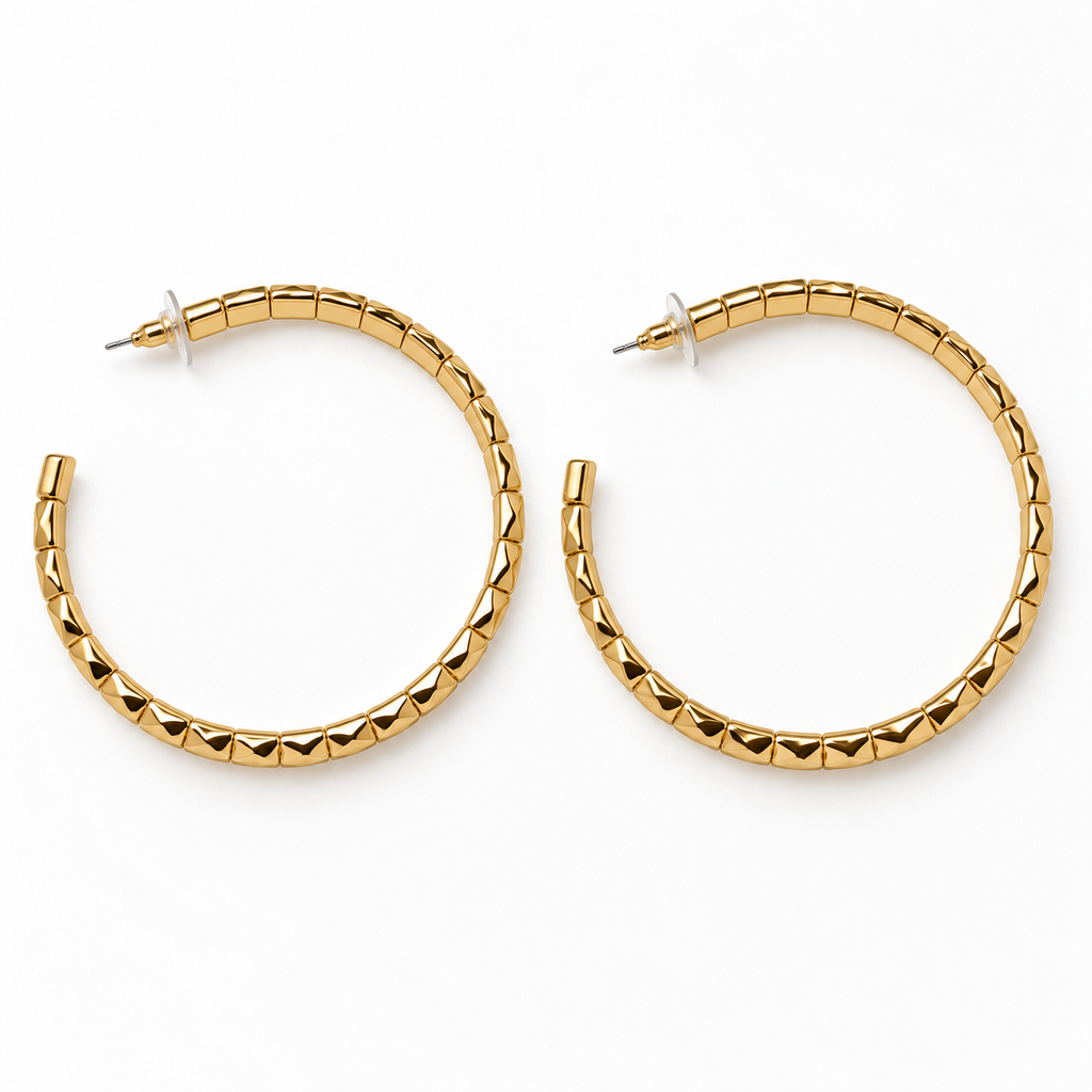 Large gold-tone faceted open hoop earrings lying flat, showing post backs