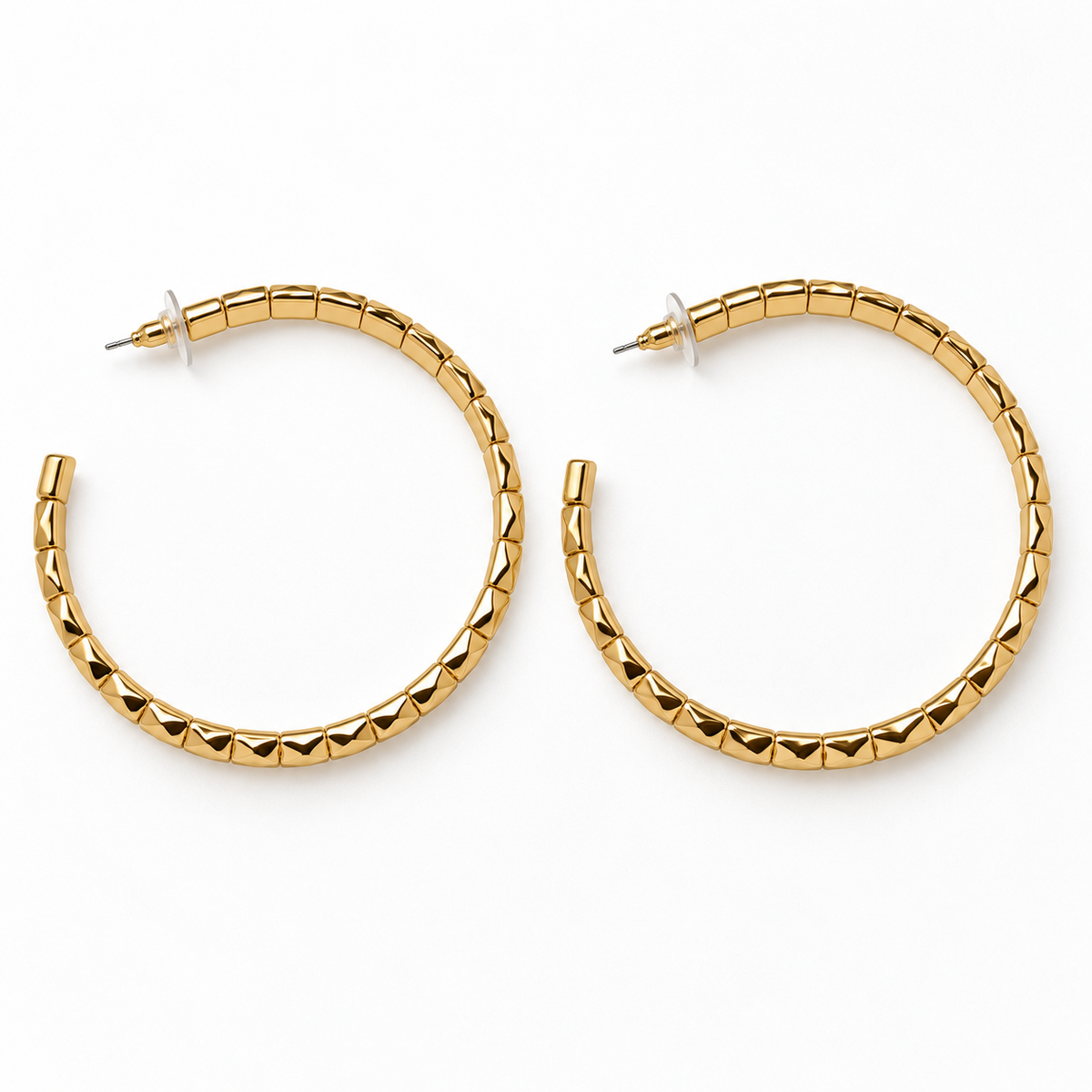 Large gold-tone faceted open hoop earrings lying flat, showing post backs