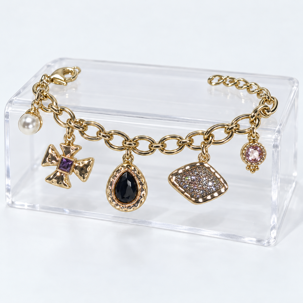 Golden Story charm bracelet on a clear acrylic display with all five charms hanging naturally