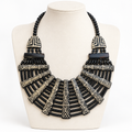 Black and cream geometric bib necklace on a pale bust, square framing