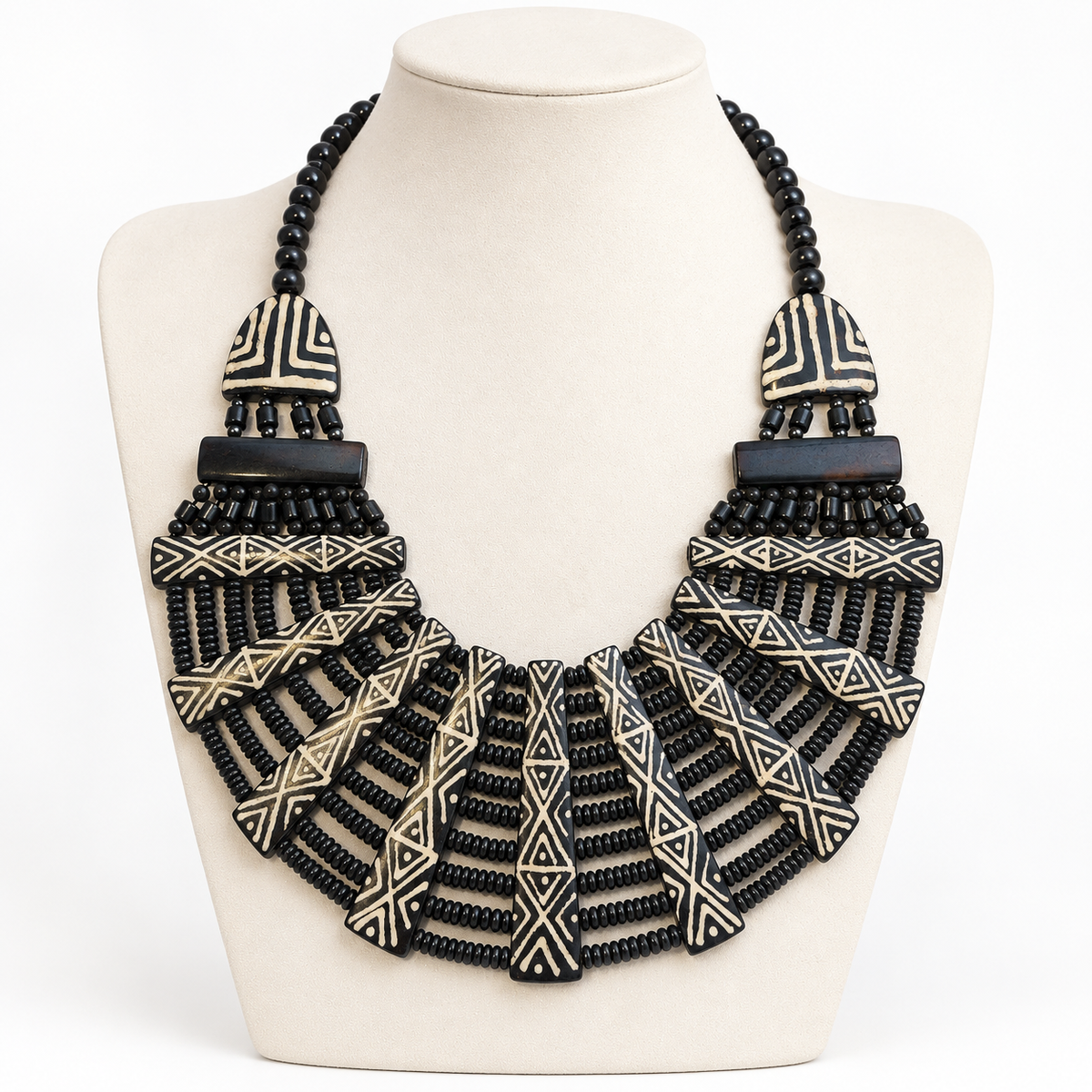 Black and cream geometric bib necklace on a pale bust, square framing