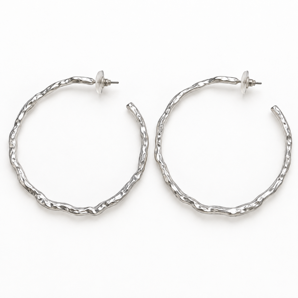 Pair of matte silver-tone wavy post-back hoop earrings laid flat on a white surface