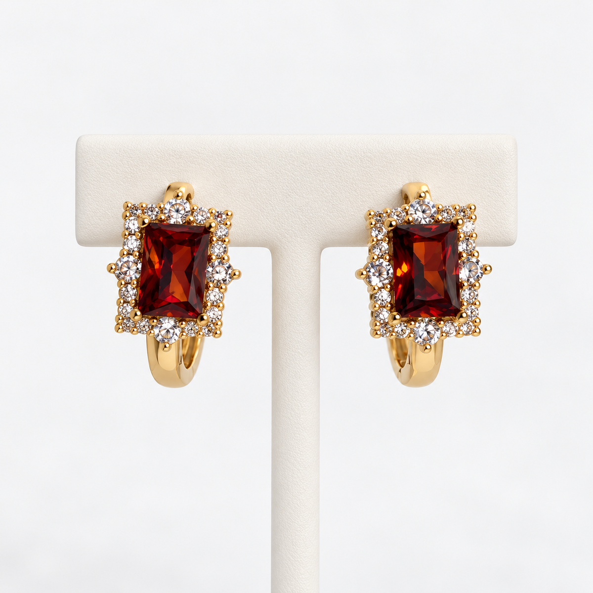 Amber rectangular halo gemstone huggie earrings on an earring holder