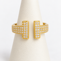 Gold adjustable double-bar ring with clear pavé stones on an ivory ring holder