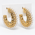 Gold-tone hammered open hoop earrings with white pearl-look trim and clear stone accents on a white holder