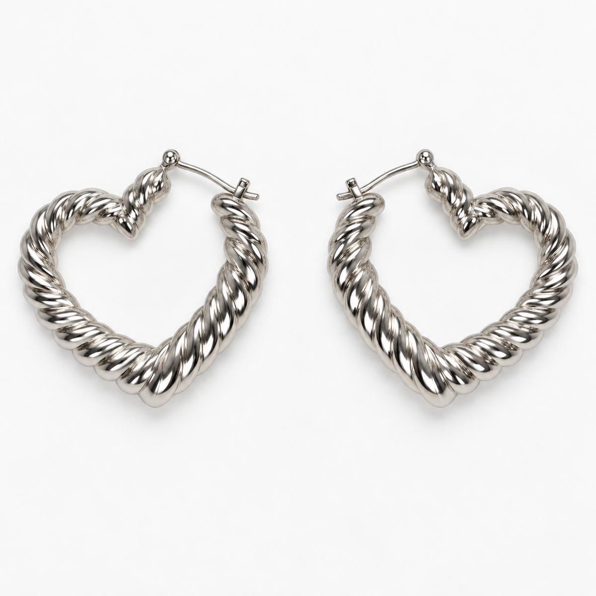 Silver-tone ribbed heart-shaped hoop earrings lying flat side by side