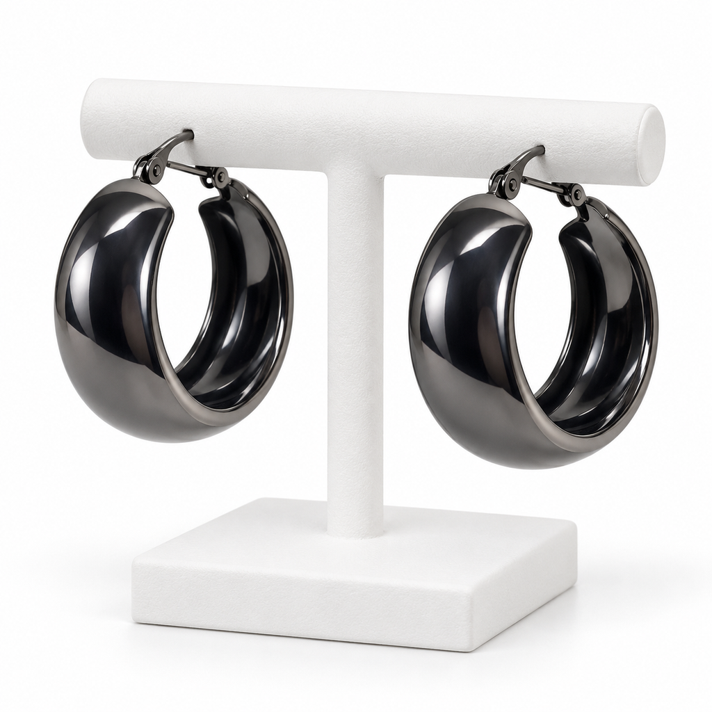Dark gunmetal medium wide hoop earrings hanging on a white holder