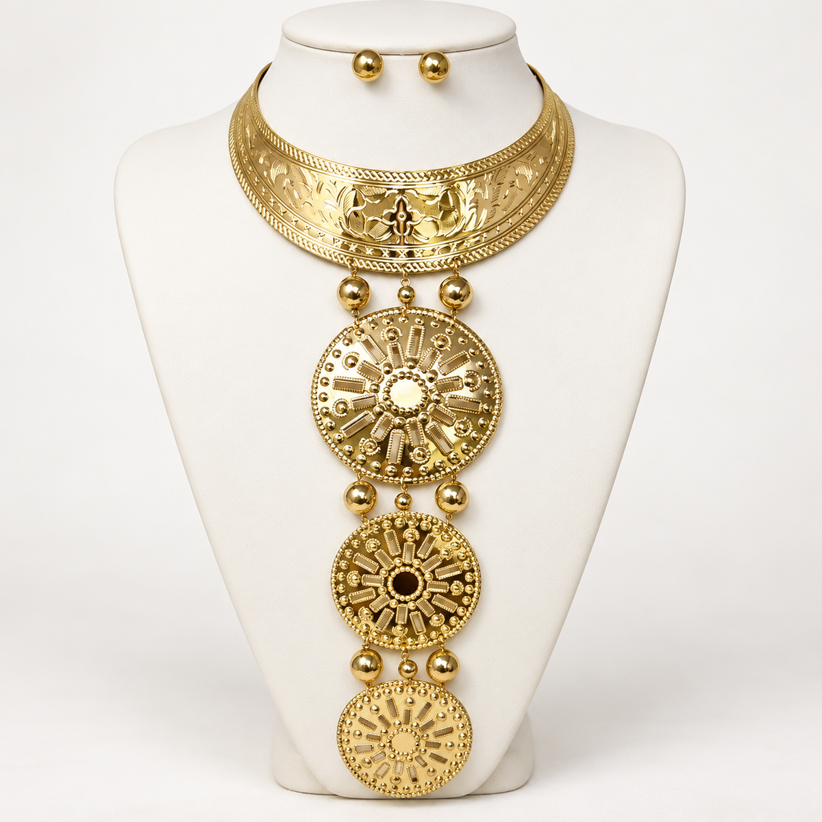 Gold-tone collar necklace with three graduated sunburst medallions on an ivory bust