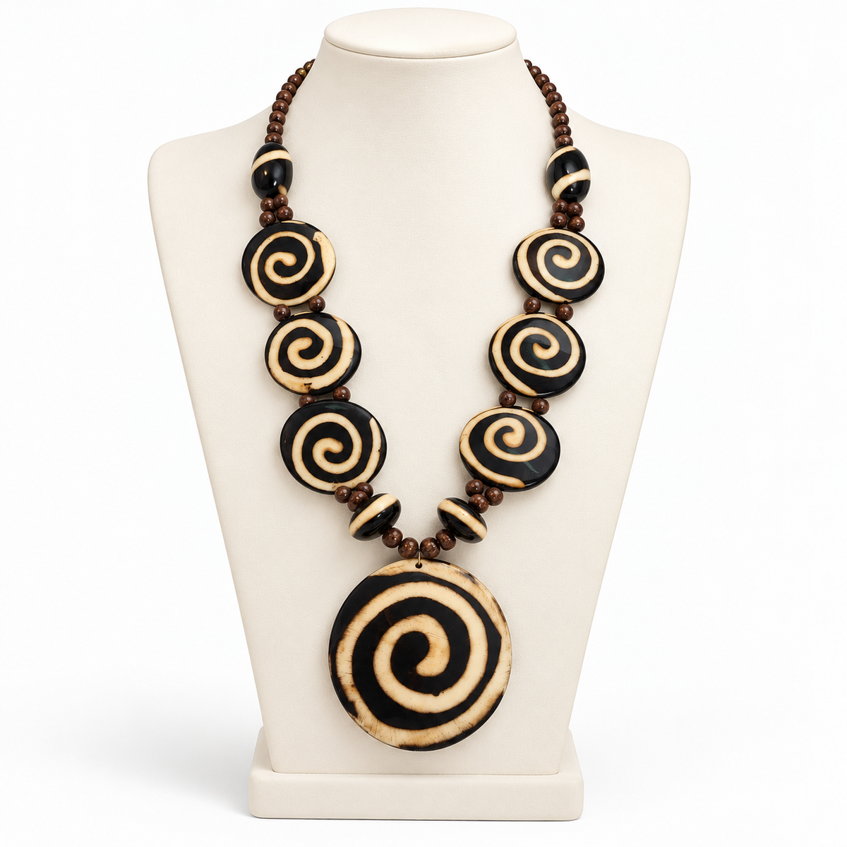 Black and cream spiral pendant necklace on a tall ivory display bust