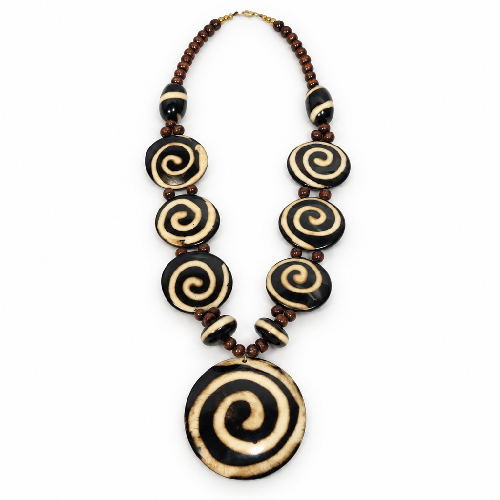 Black and cream spiral pendant necklace laid flat on a light background