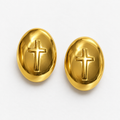Pair of gold-tone stainless steel oval cross post-back stud earrings laid flat