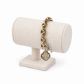 Two-tone link bracelet with a sparkling clover charm on a light bracelet holder