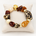 Leopard-print, brown, amber and cream beaded stretch bracelet on an ivory cushion
