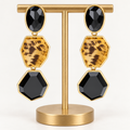 Black and leopard-print three-tier post-back earrings on a gold holder