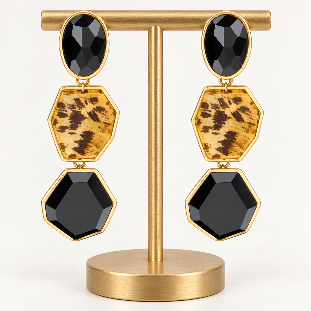 Black and leopard-print three-tier post-back earrings on a gold holder