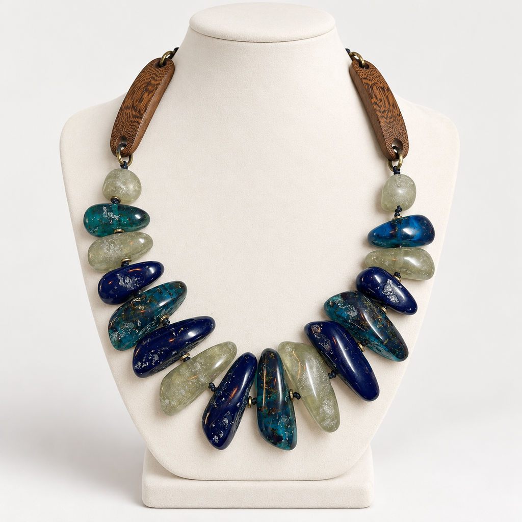 Blue hand-tied wood and chunky resin necklace on an ivory jewelry display bust